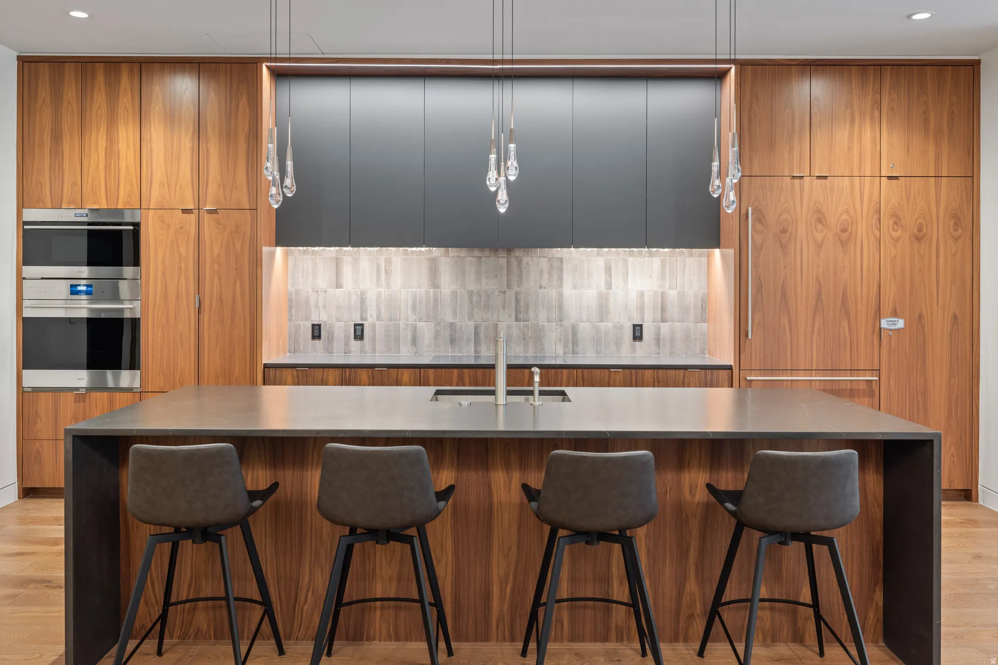 Kitchen with brown cabinetry, modern cabinets, a large island, a kitchen breakfast bar, and recessed lighting