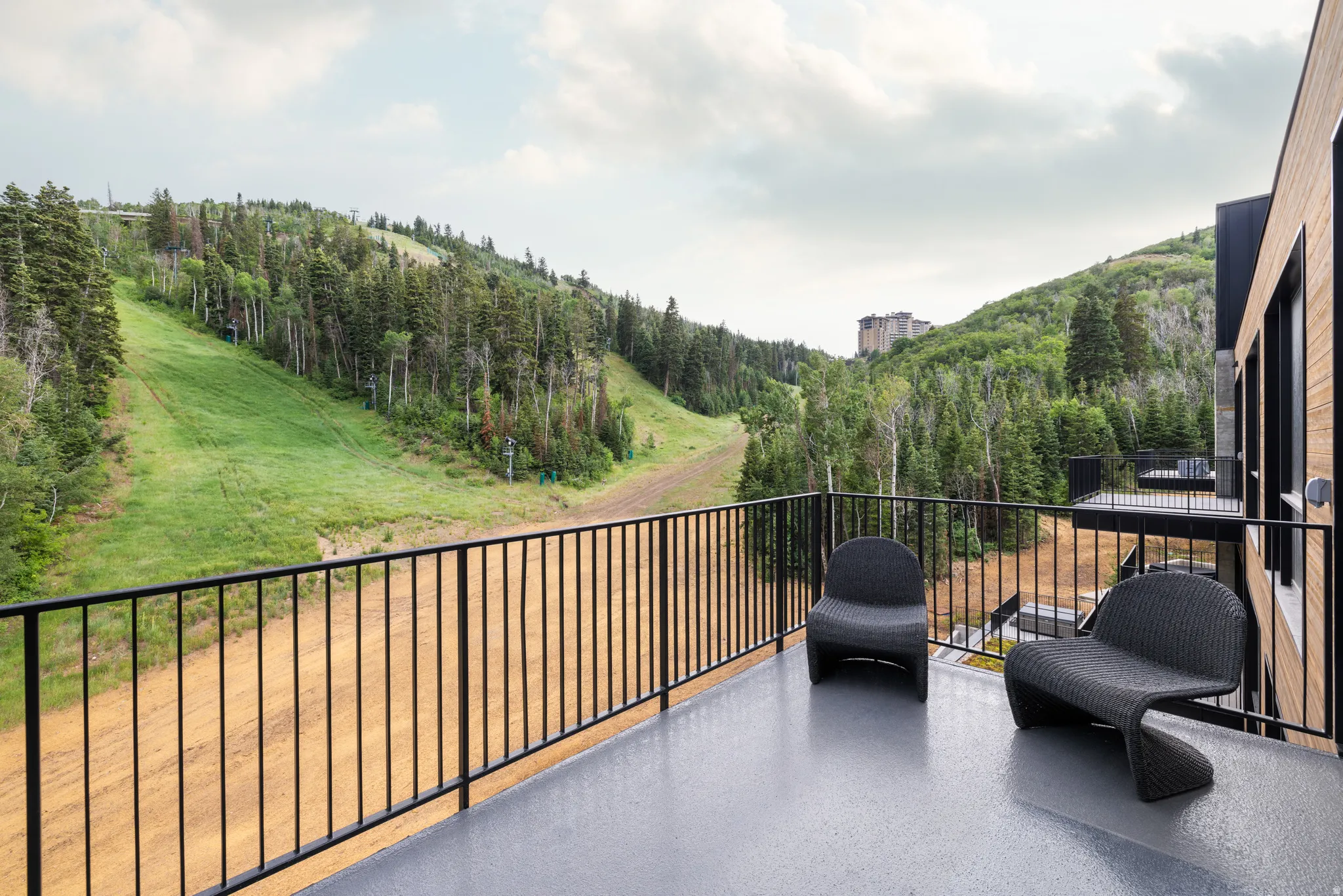 Balcony featuring a wooded view