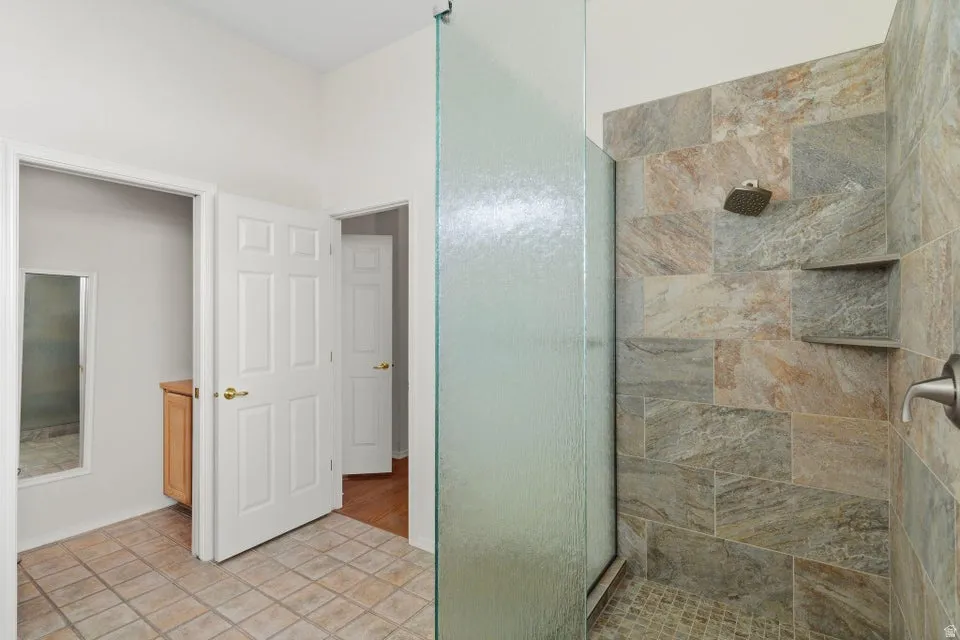 Bathroom with a shower stall and light tile patterned flooring