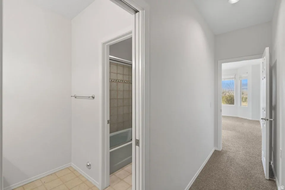 Corridor featuring light colored carpet and light flooring