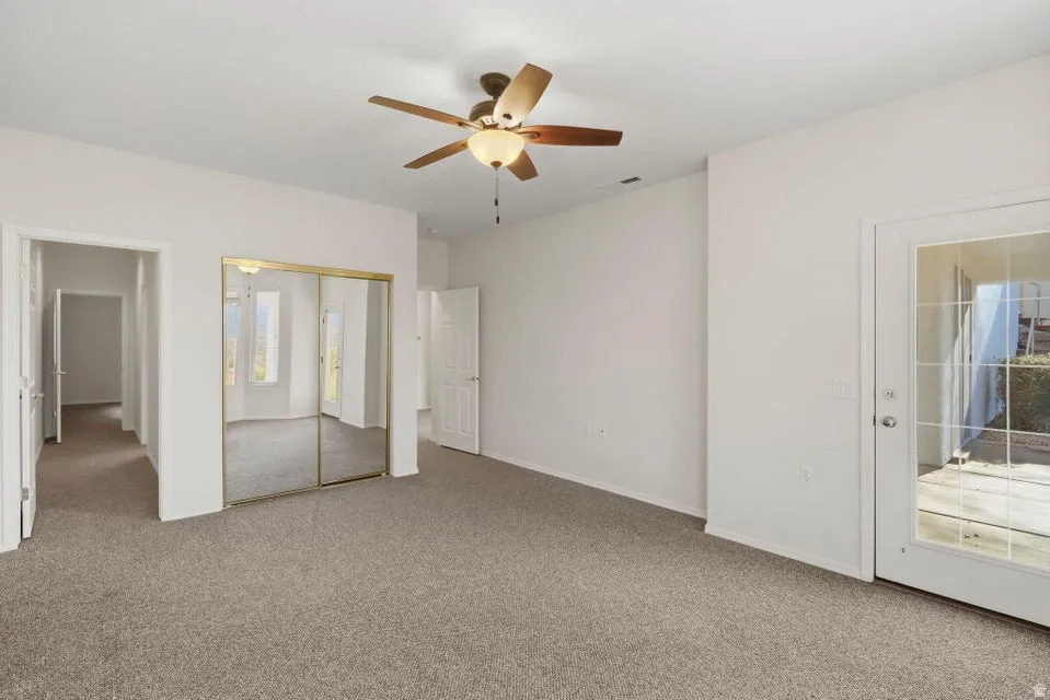 Unfurnished bedroom with light carpet, a ceiling fan, and a closet