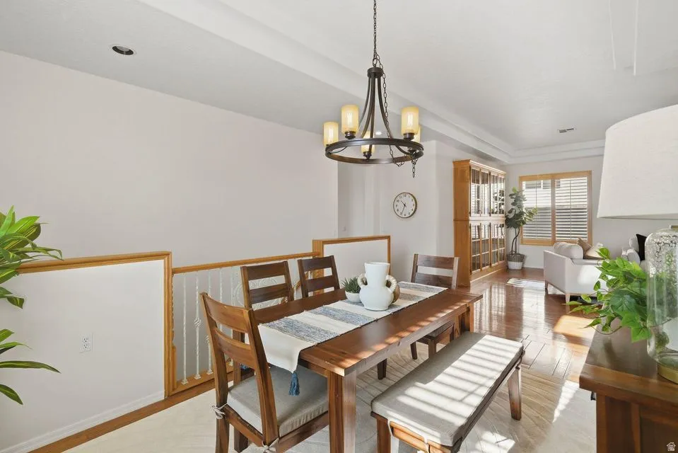 Dining room with light wood-style flooring and a chandelier