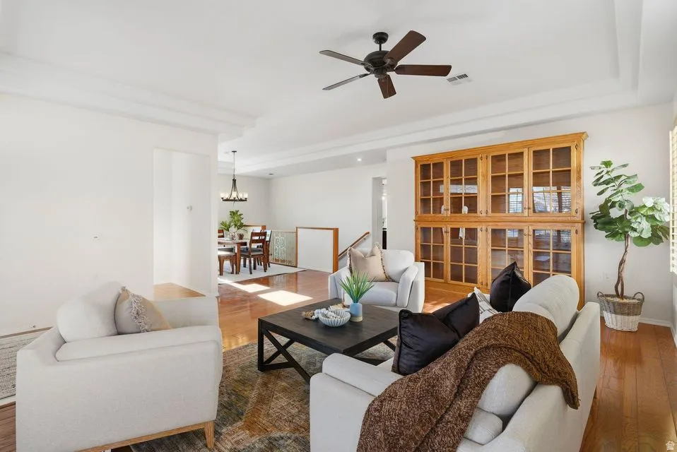 Living area featuring hardwood / wood-style flooring, ceiling fan, and a chandelier