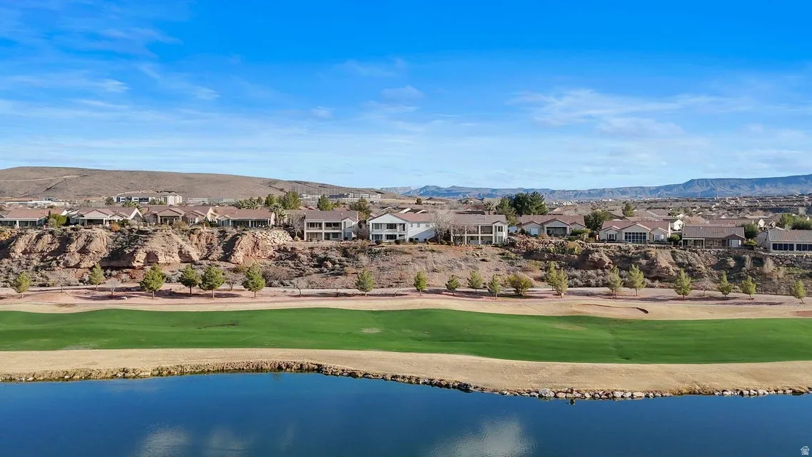 Aerial perspective of suburban area with a water and mountain view and a local golf course