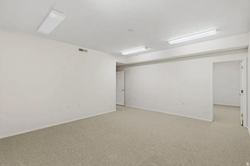 Carpeted spare room with baseboards