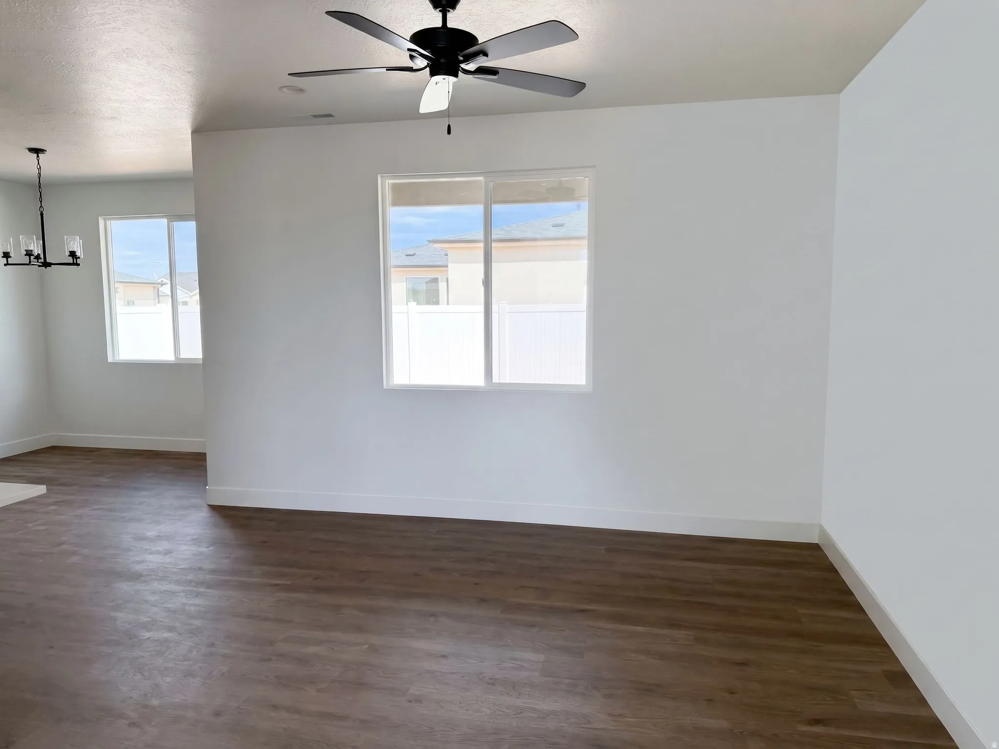 Wood-finish flooring, white walls, and a ceiling fan