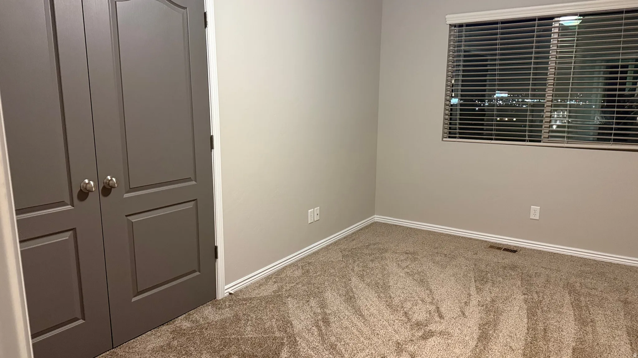Empty room featuring carpet and baseboards