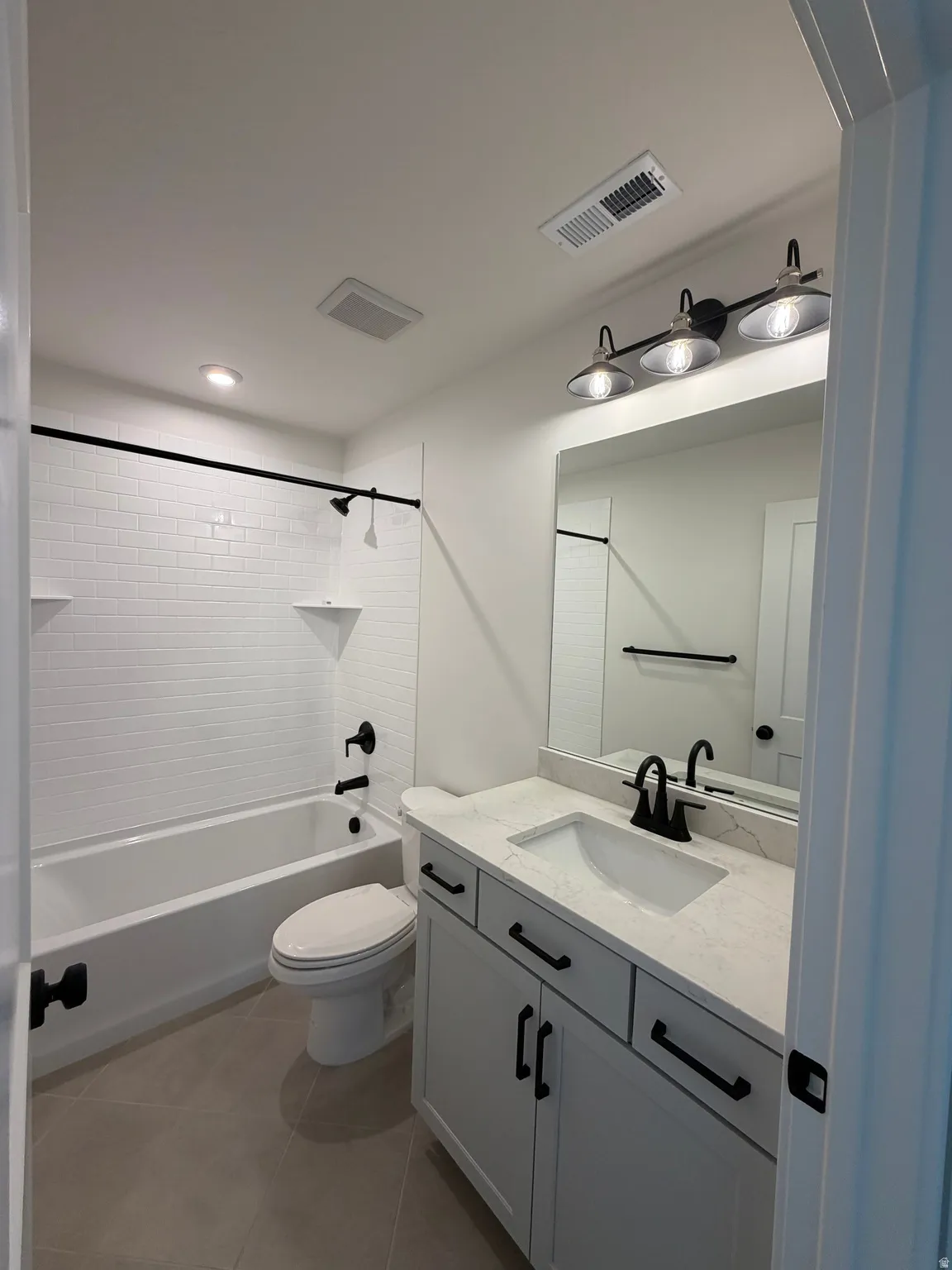 Full bathroom featuring vanity, bathing tub / shower combination, light tile patterned floors, and recessed lighting