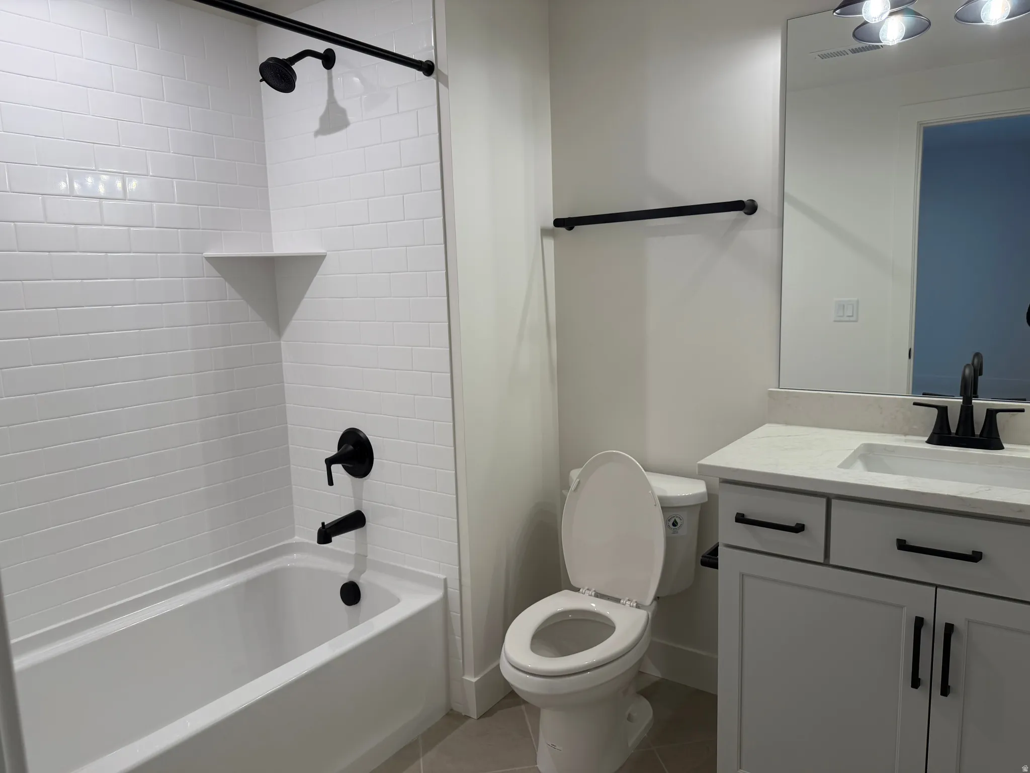 Full bathroom with vanity, shower / tub combination, and light tile patterned floors