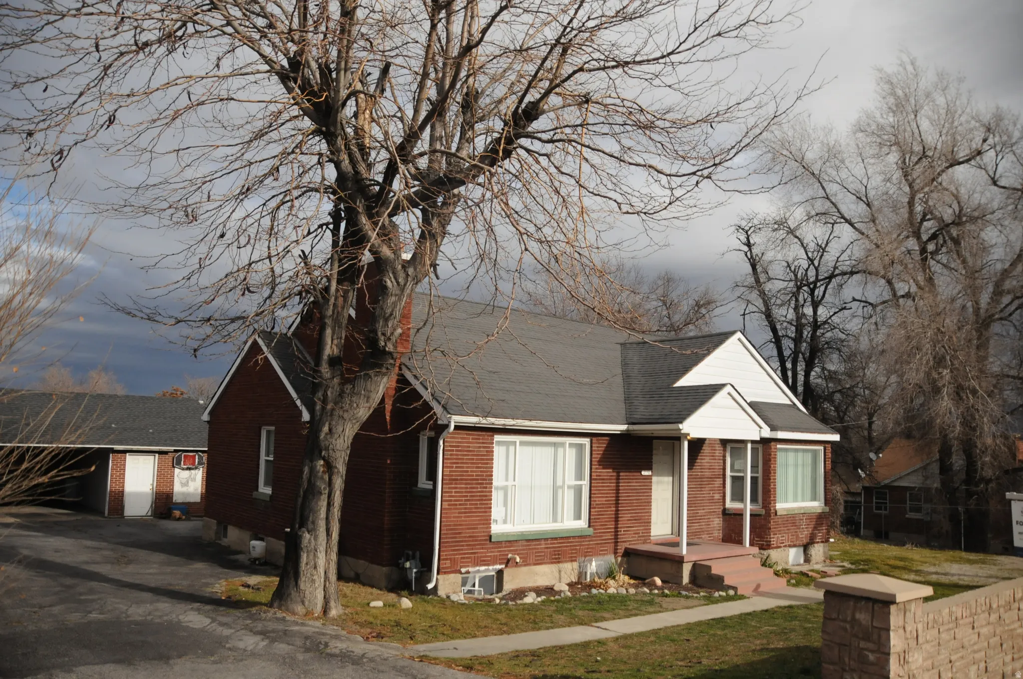 View of front facade with brick siding and a shingled roof