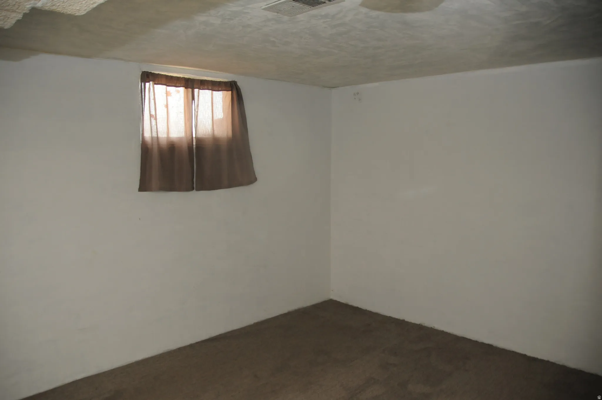 Spare room with a textured ceiling and dark carpet