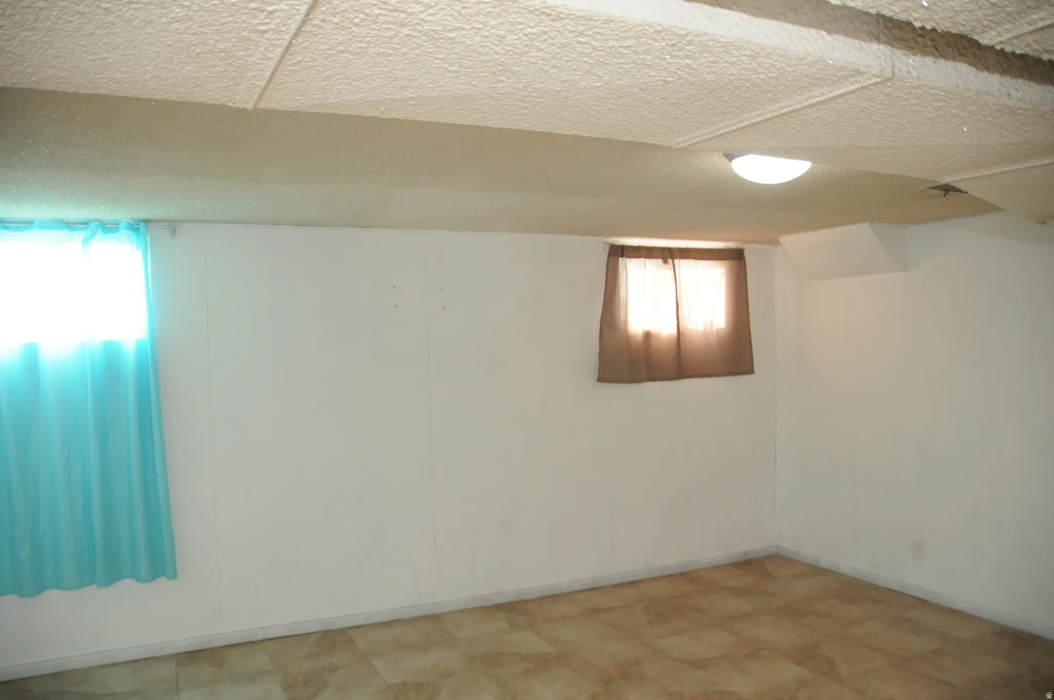 Basement featuring a textured ceiling and tile patterned floors