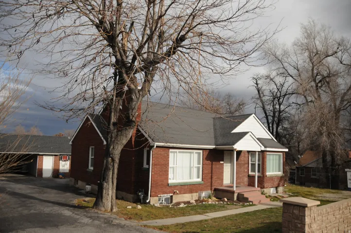 View of front facade with brick siding and a shingled roof