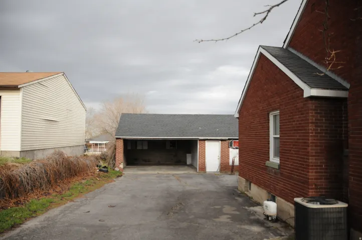 View of home's exterior featuring roof with shingles and brick siding