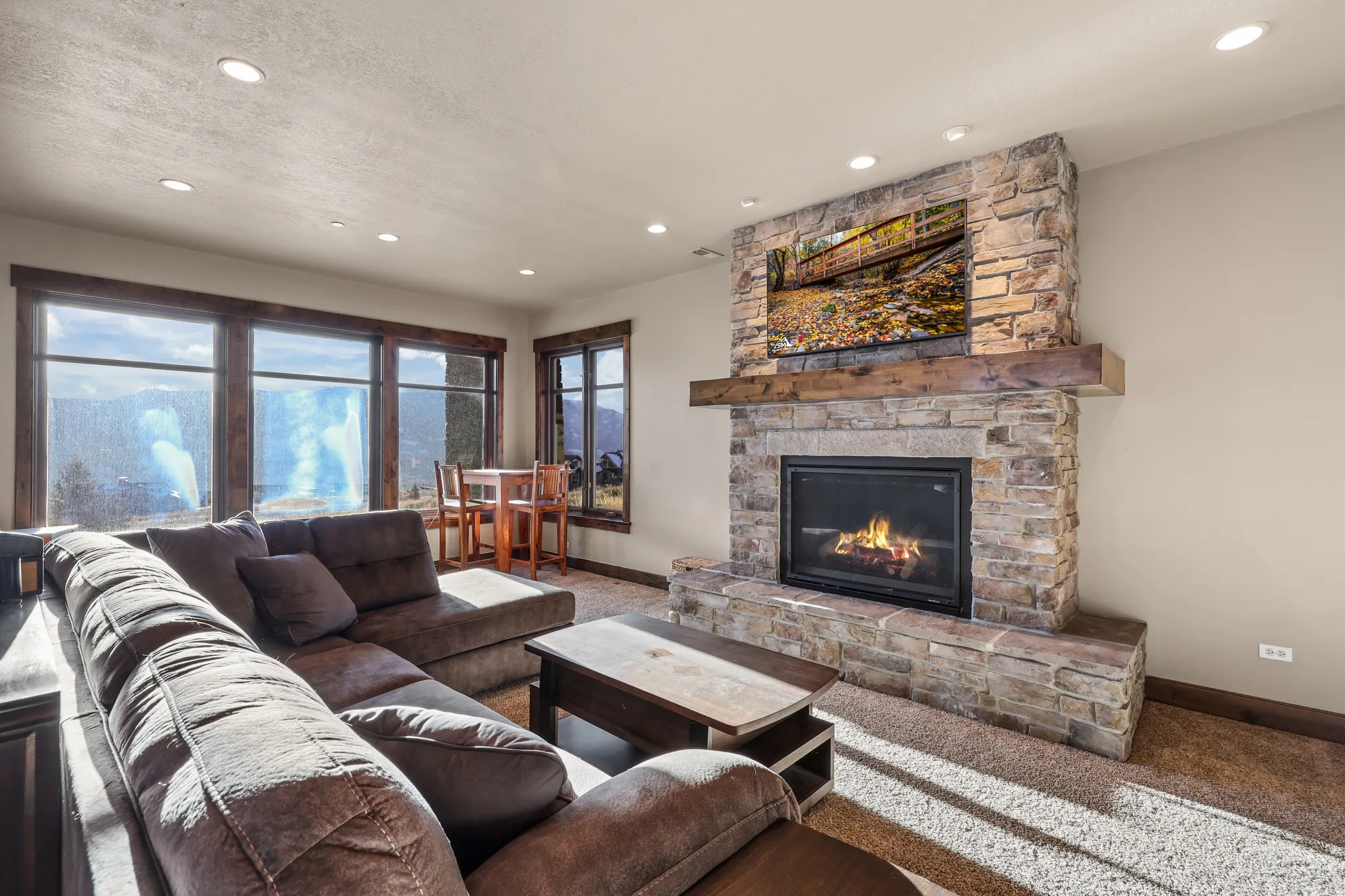 Living area with a stone fireplace, carpet floors, and recessed lighting
