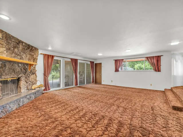 Unfurnished living room featuring a fireplace, carpet, plenty of natural light, and recessed lighting