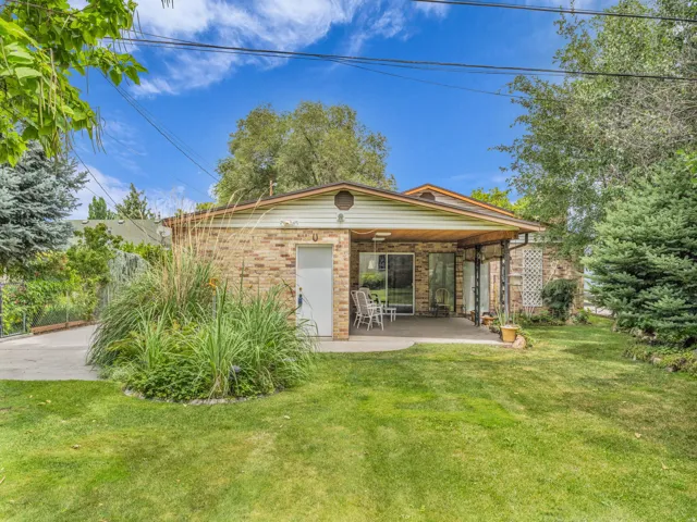 Back of house featuring a patio area, a yard, and brick siding