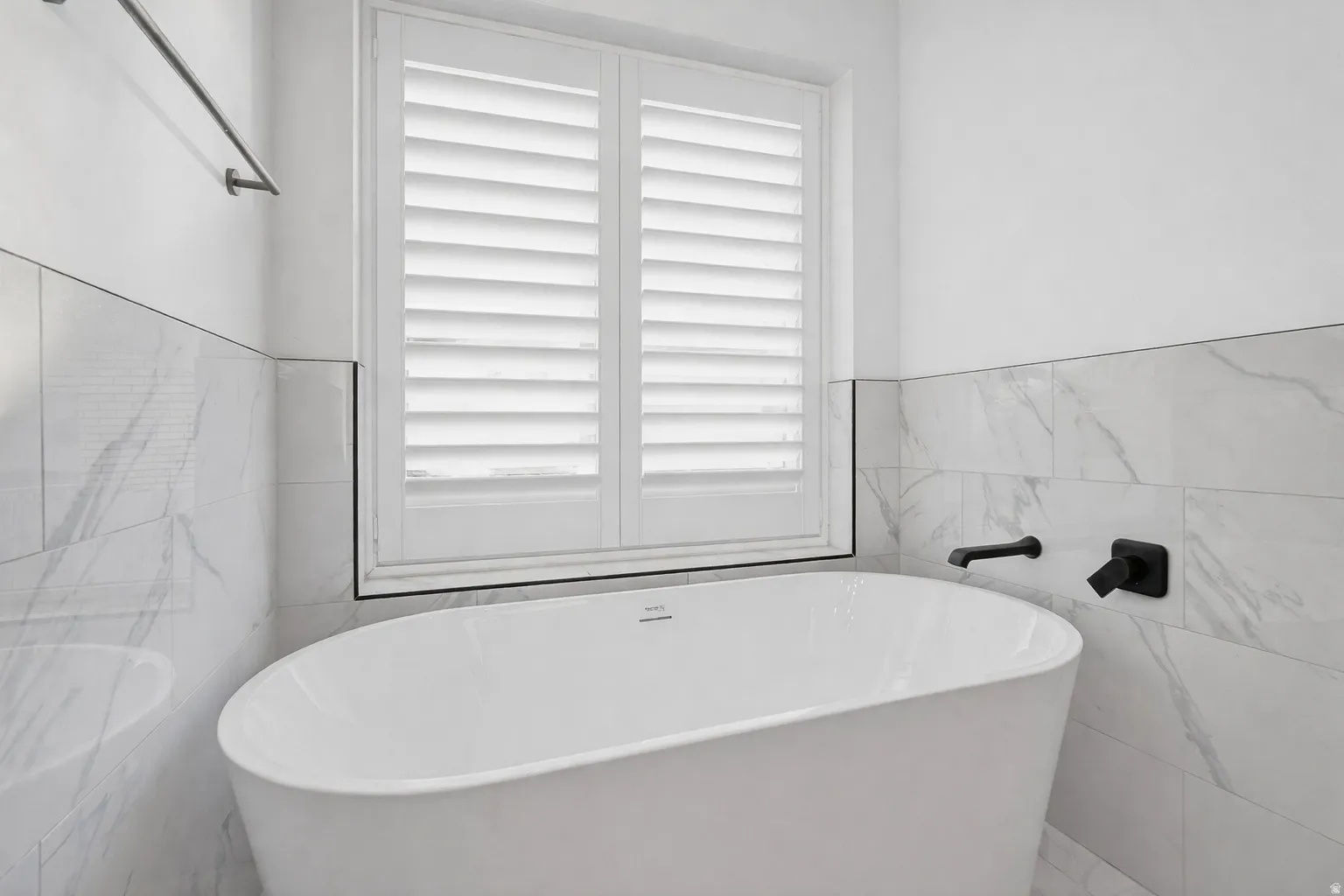 Full bath with a freestanding tub and tile walls