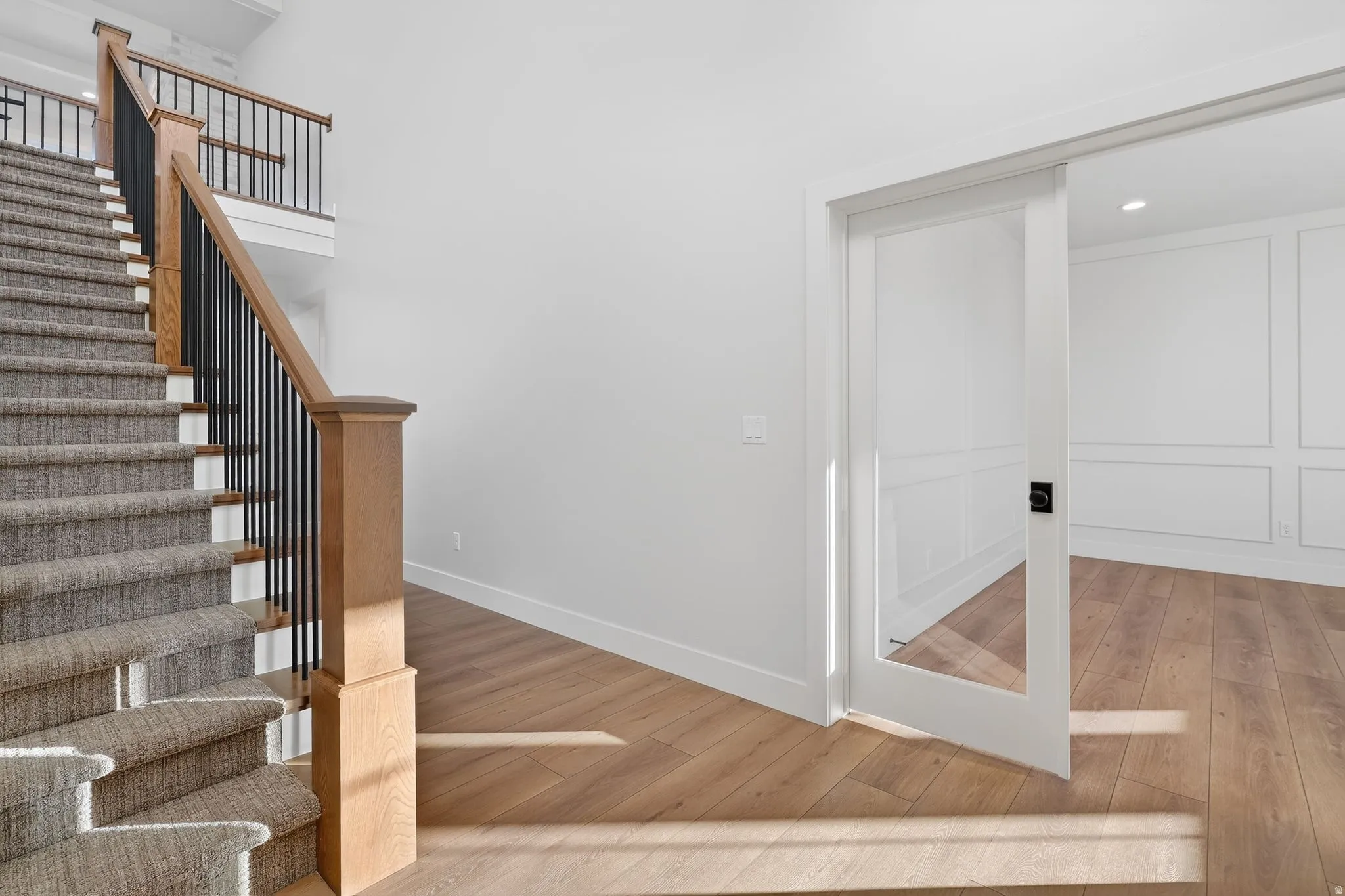 Stairs flanked with wood finished floors and baseboards, Glass 8' French doors to an large executive office or studio