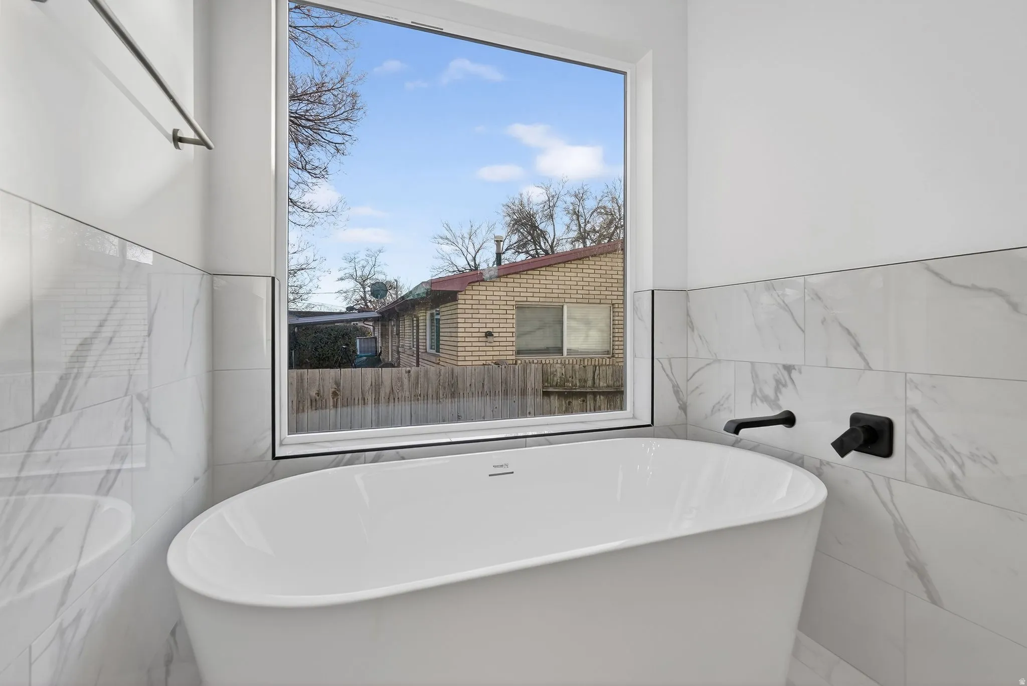 ensuite Bathroom  featuring tile walls and a soaking tub