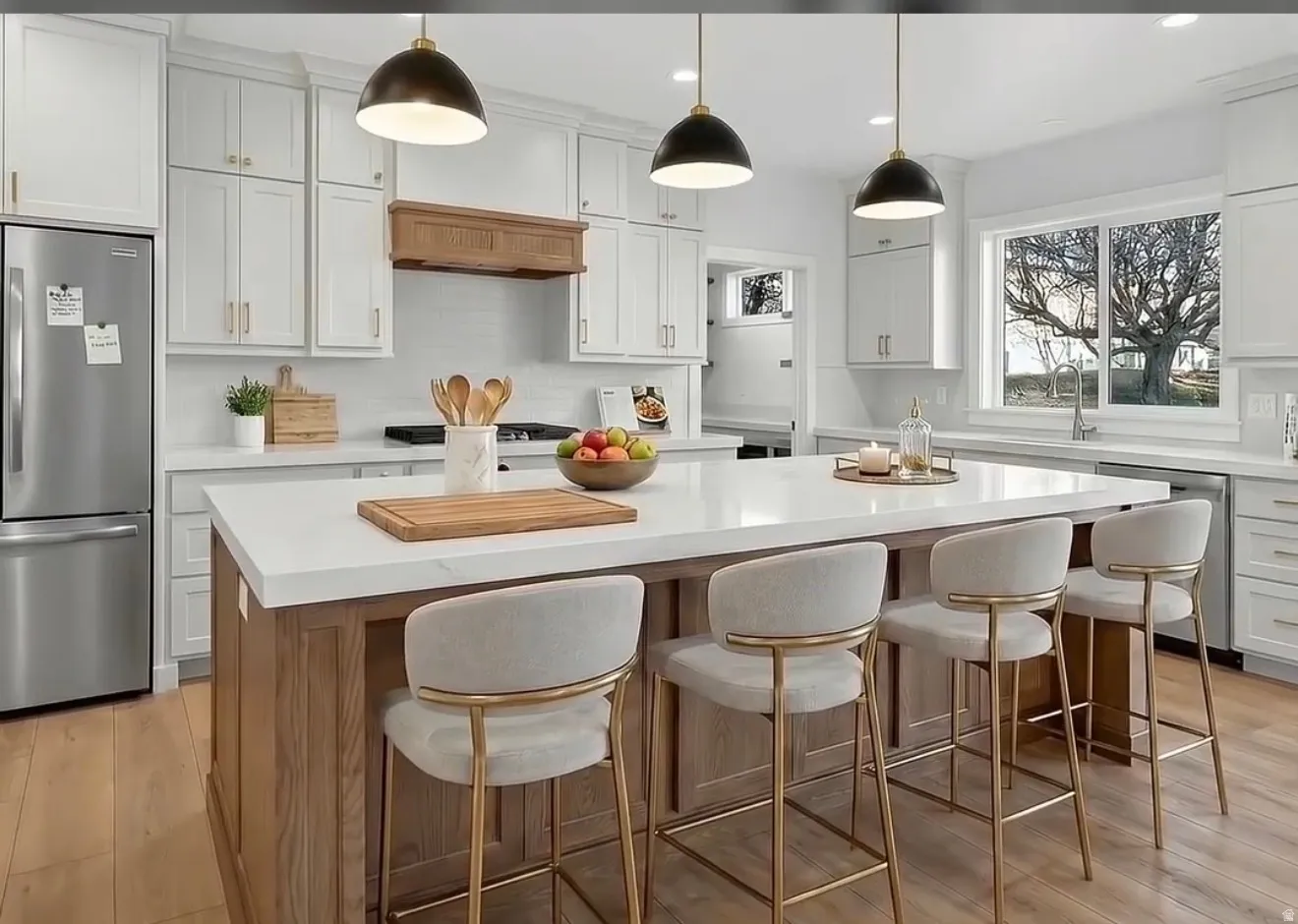 Kitchen with appliances with stainless steel finishes, light wood-type flooring, white cabinetry, decorative light fixtures, and recessed lighting