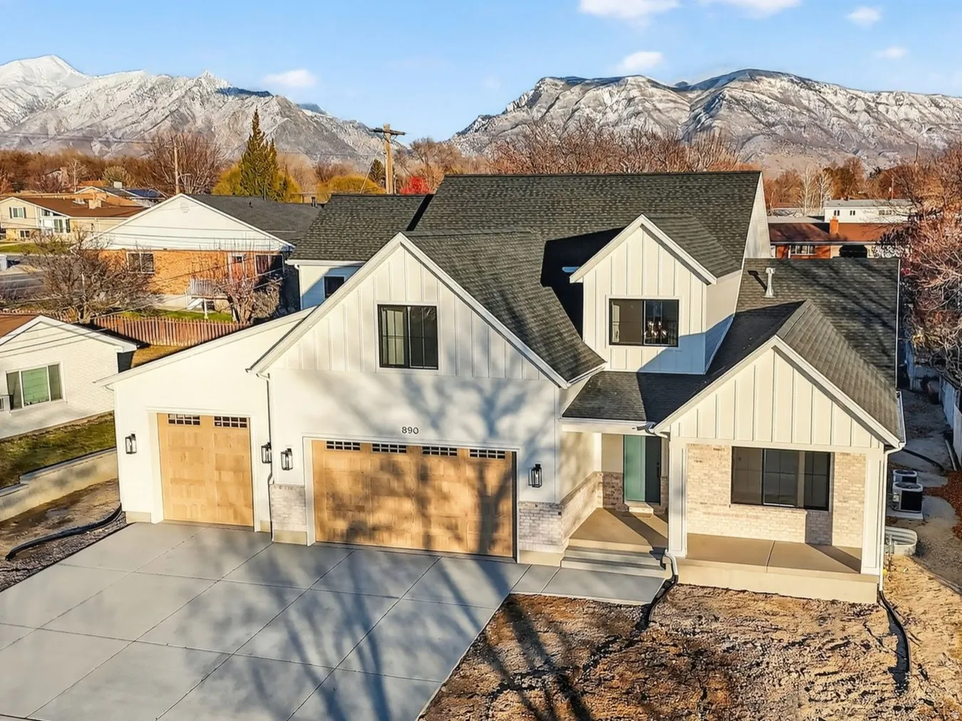 Mountain View of front of house featuring board and batten siding, roof with shingles, concrete driveway, a mountain view, and brick siding