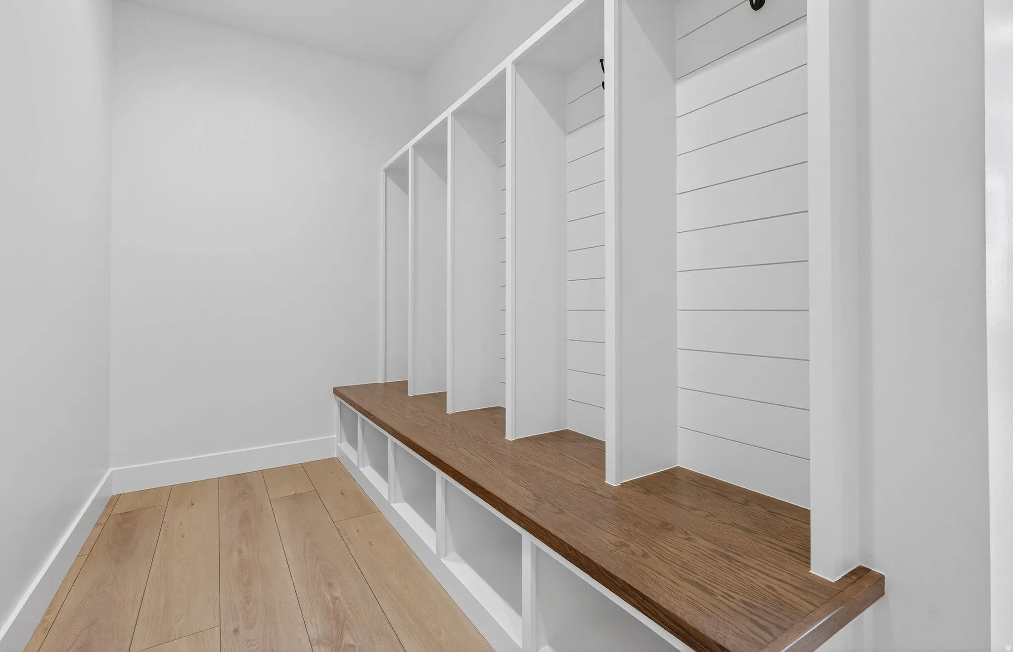 Mudroom with light wood-style flooring and baseboards