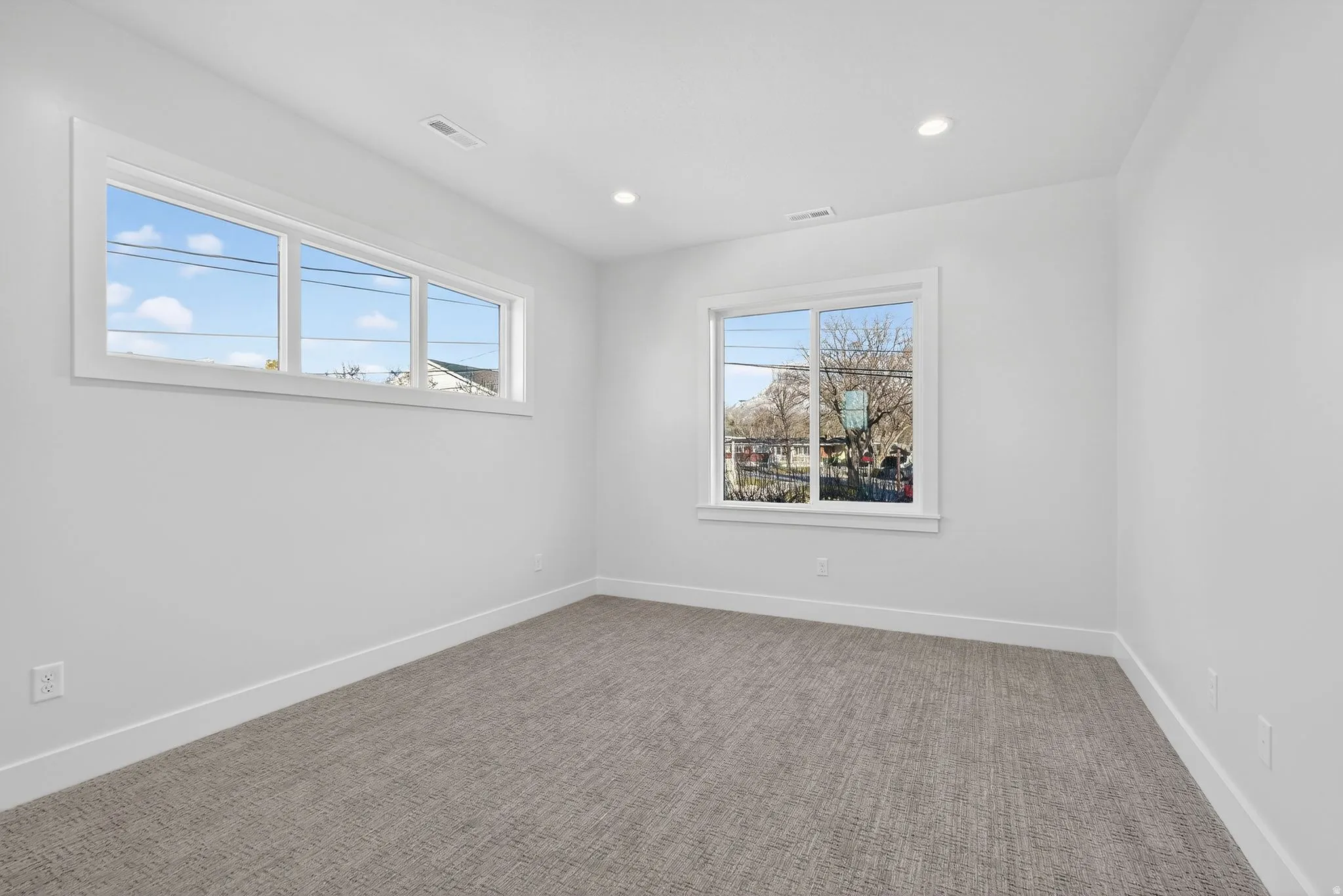 another bedroom with light colored carpet and recessed lighting, walk-in closets
