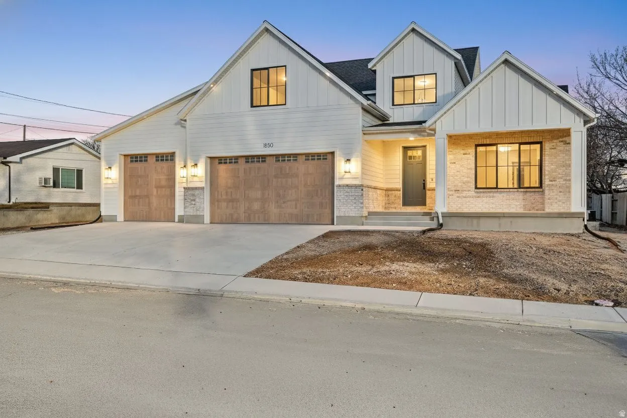 Modern farmhouse with covered porch, board and batten siding, concrete driveway, and brick and siding. 13' garage door for RV, side garage man door.