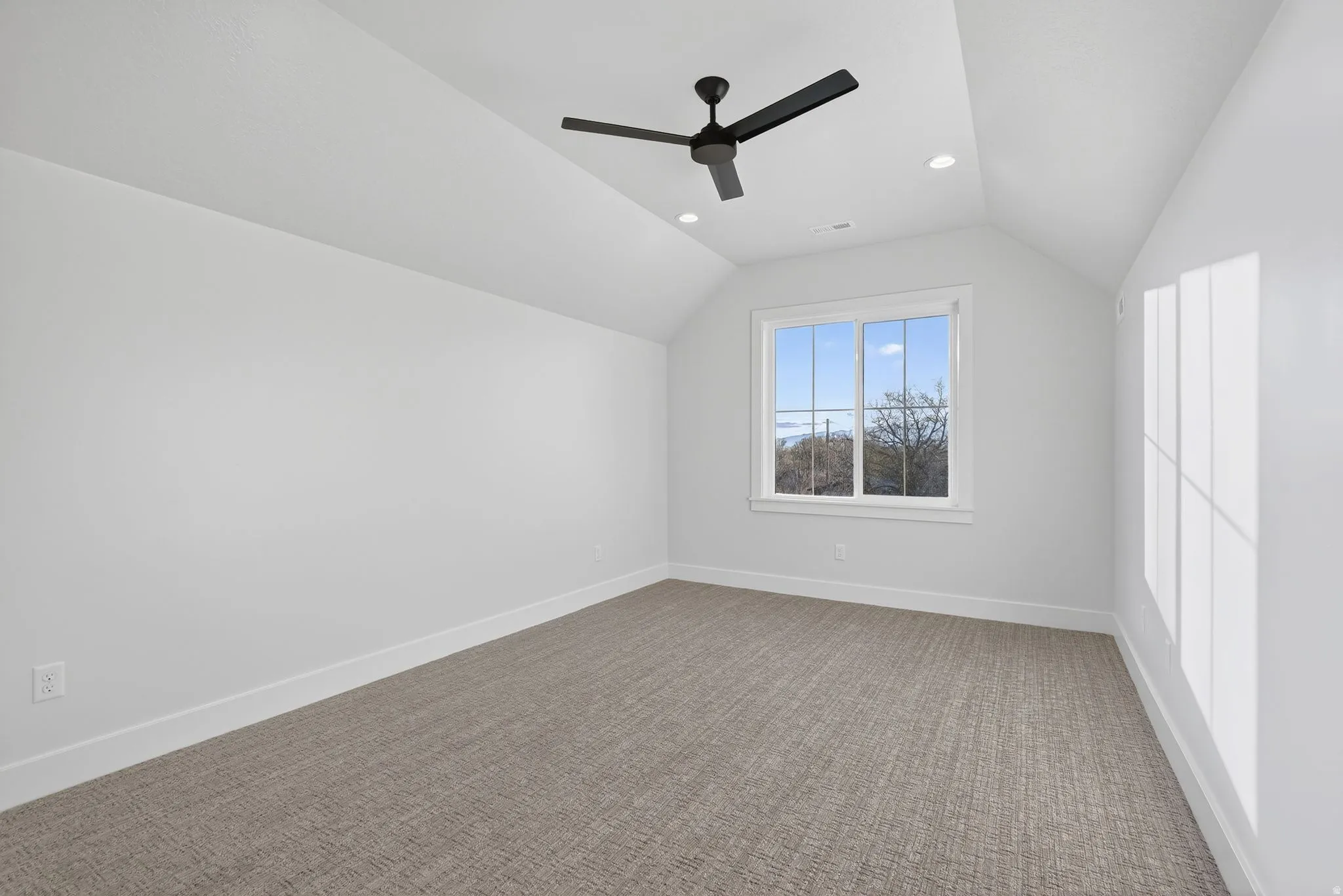 Huge Bonus room over the garage or another bedroom with vaulted ceiling, recessed lighting, light carpet, and a ceiling fan and huge walk-in closet.