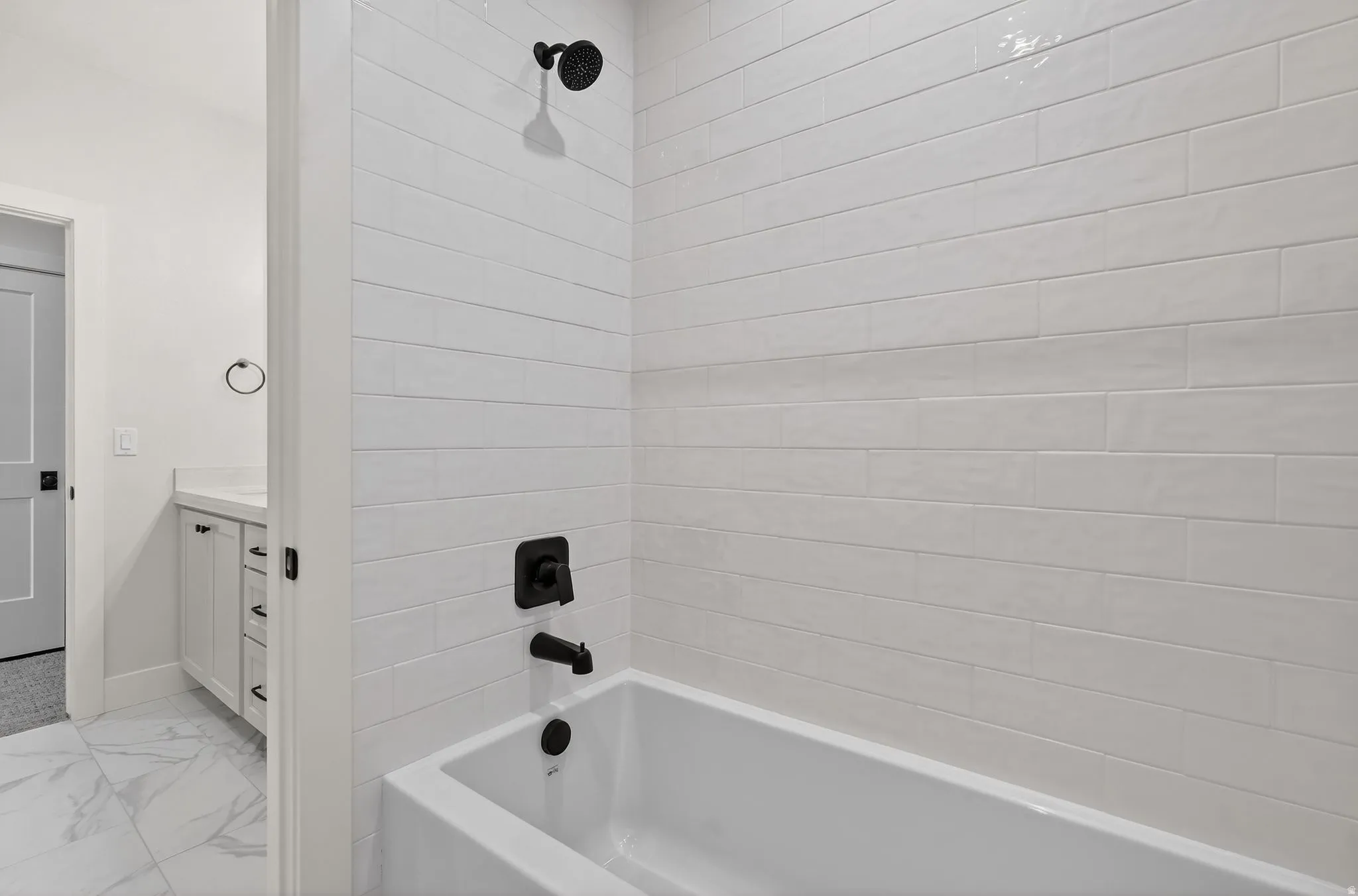 Full bathroom with vanity, shower / washtub combination, and light marble finish flooring
