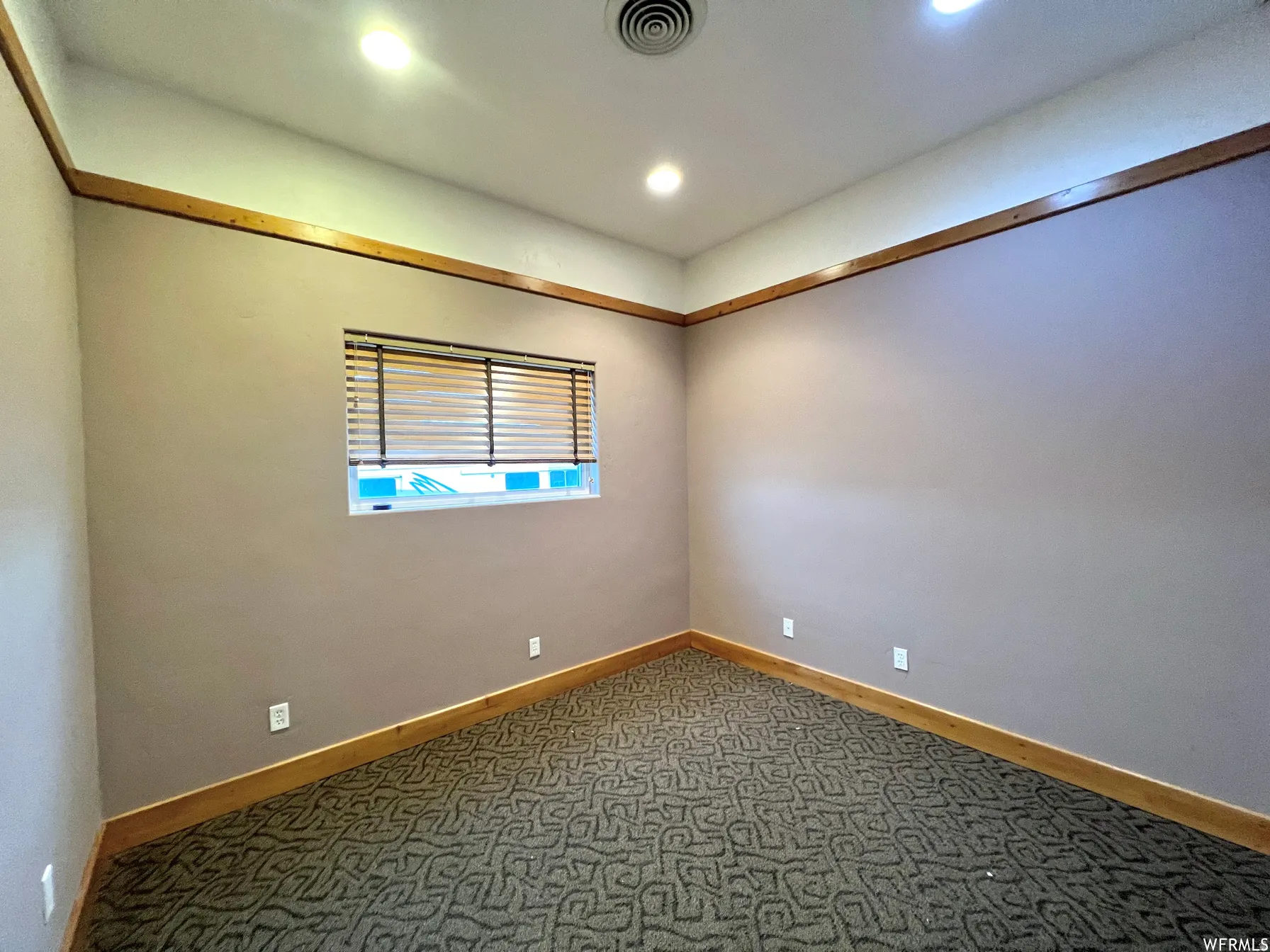 Carpeted empty room featuring baseboards and recessed lighting