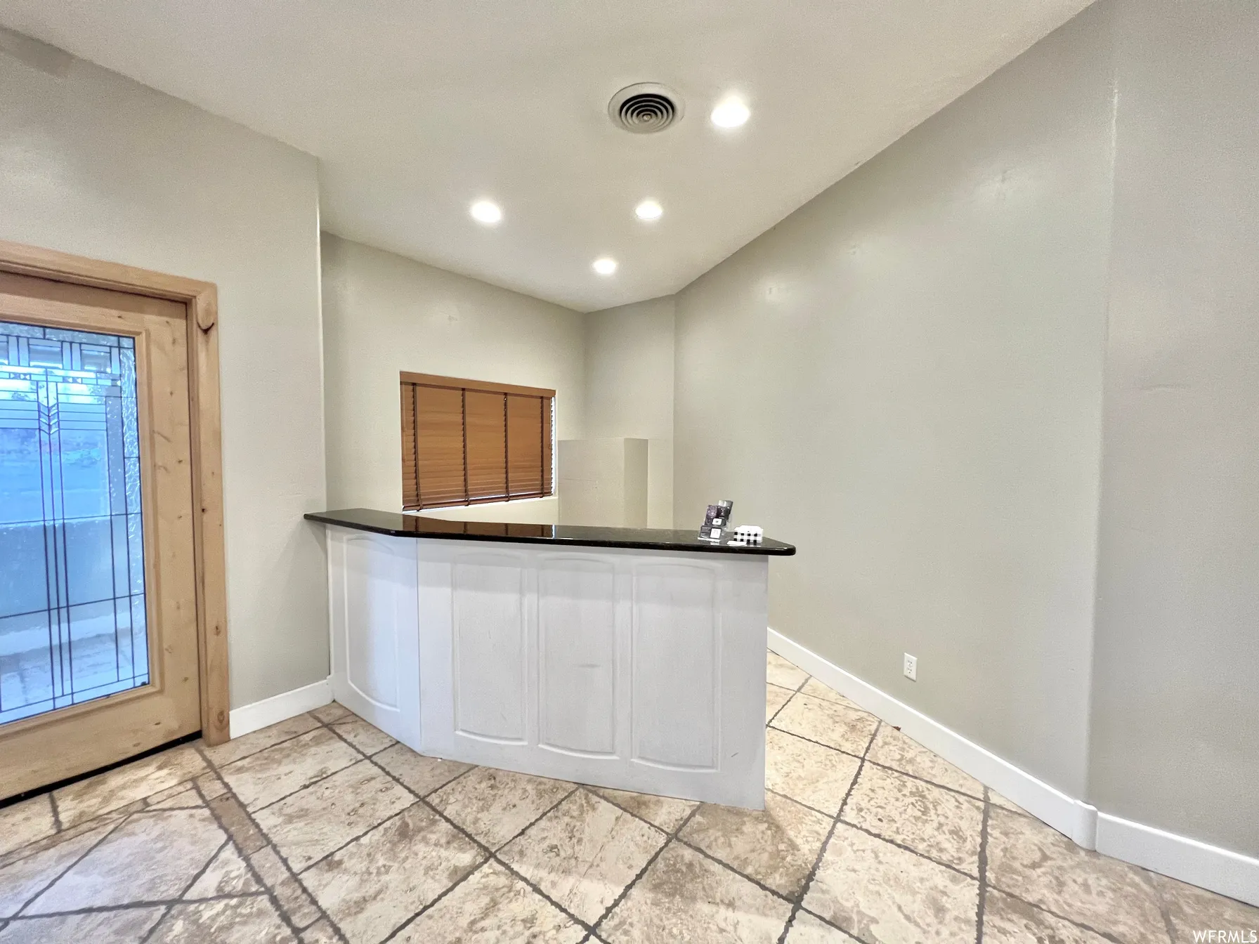 Kitchen with dark countertops, recessed lighting, and a peninsula