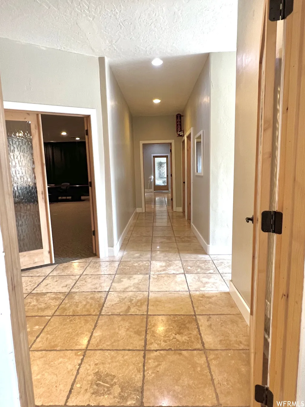 Corridor with a textured ceiling and recessed lighting
