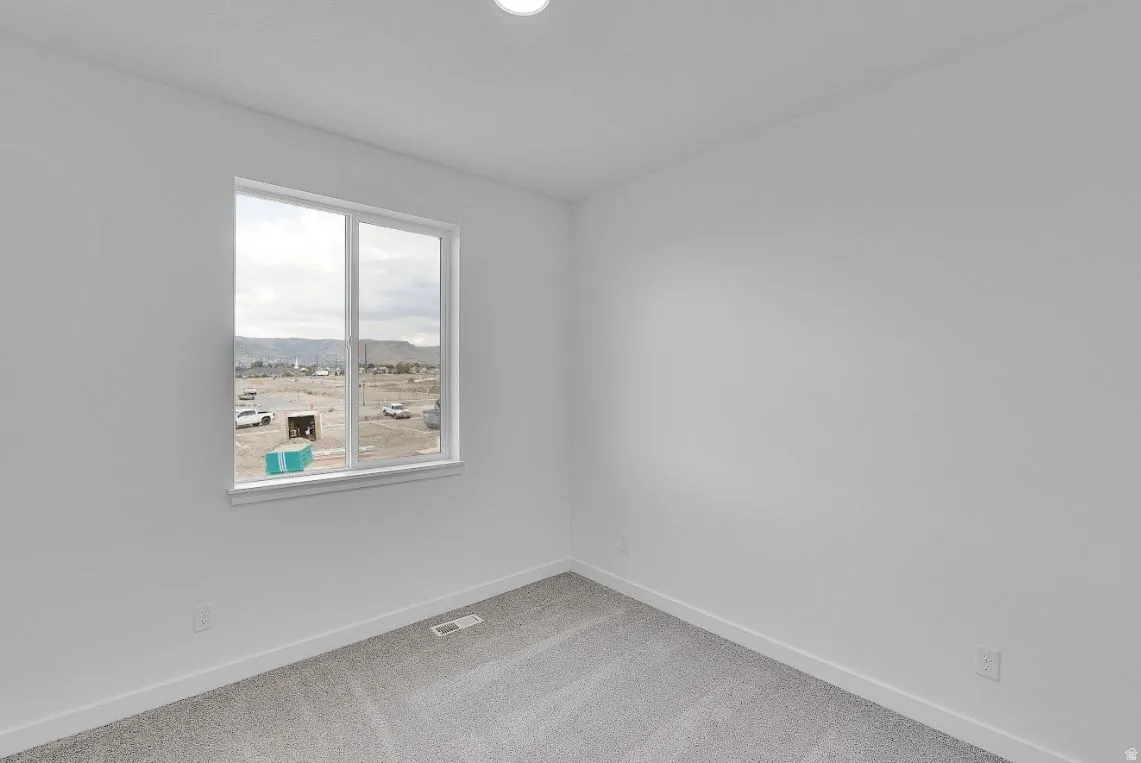 Empty room featuring baseboards and carpet flooring