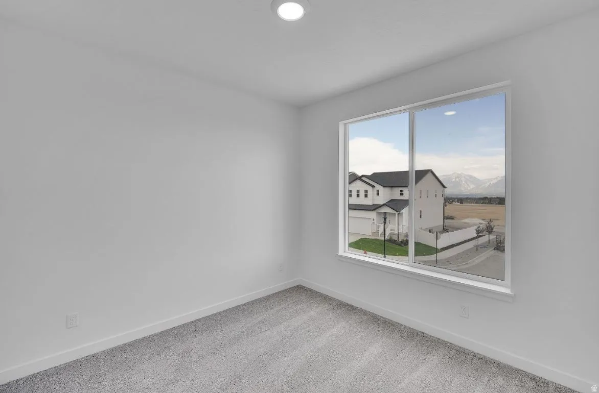 Carpeted empty room featuring baseboards