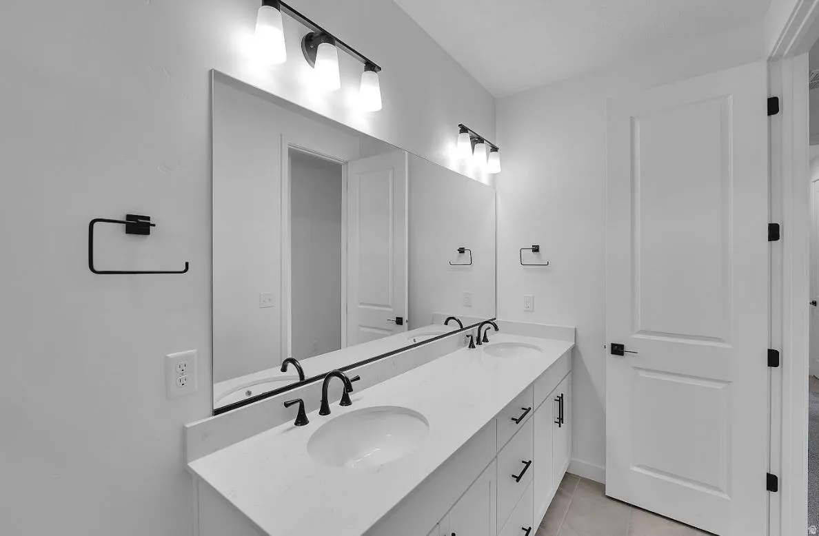 Bathroom with double vanity and light tile patterned flooring