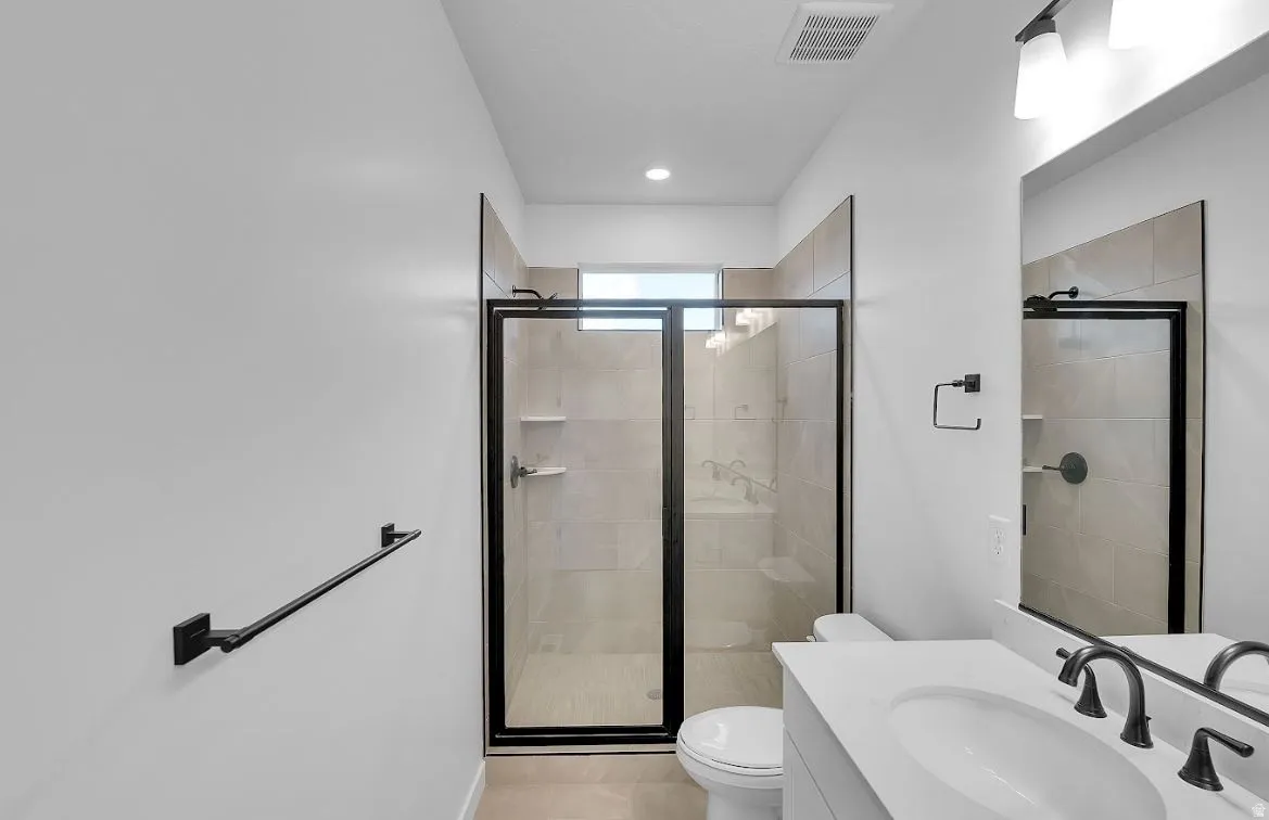 Bathroom featuring vanity, a shower stall, and recessed lighting