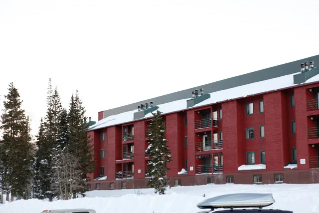 Snow covered building with a view of apartment building / complex