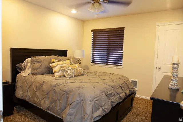 Bedroom with dark carpet, a ceiling fan, and recessed lighting