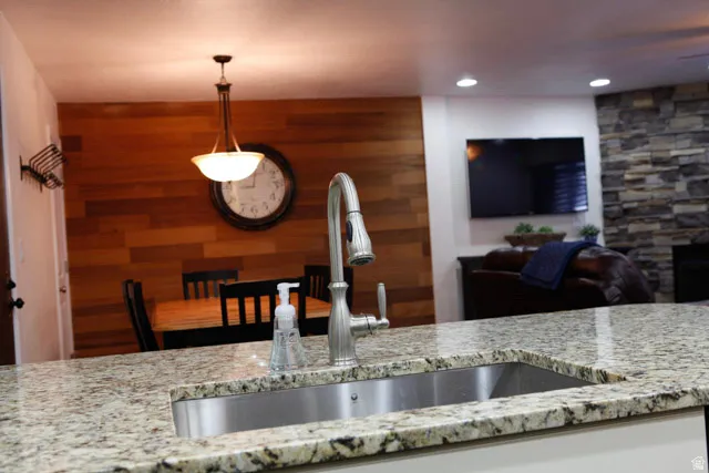 Kitchen with light stone countertops, recessed lighting, and decorative light fixtures