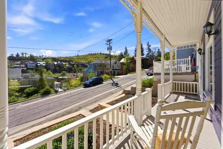 Covered front porch featuring decorative white balusters, turned columns, and a beadboard ceiling