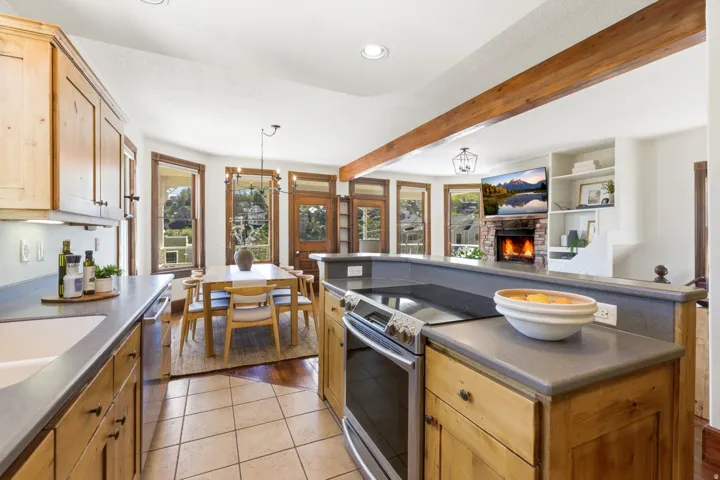 Kitchen featuring light wood cabinetry, stone countertops, and tile flooring