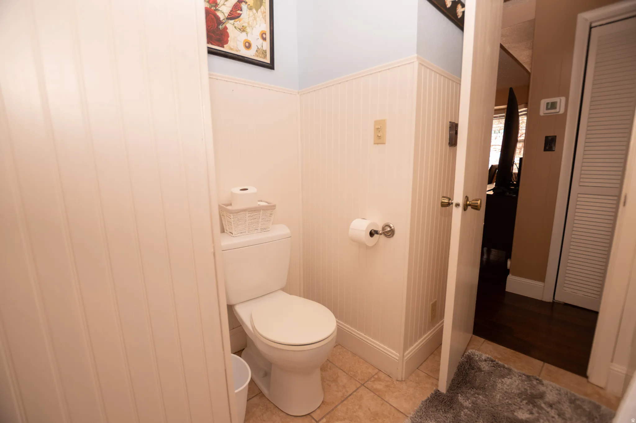 Half bath with toilet and light tile patterned floors