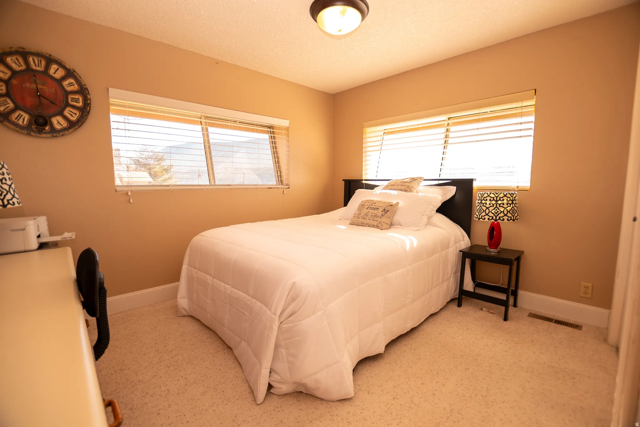 Bedroom with multiple windows and a textured ceiling