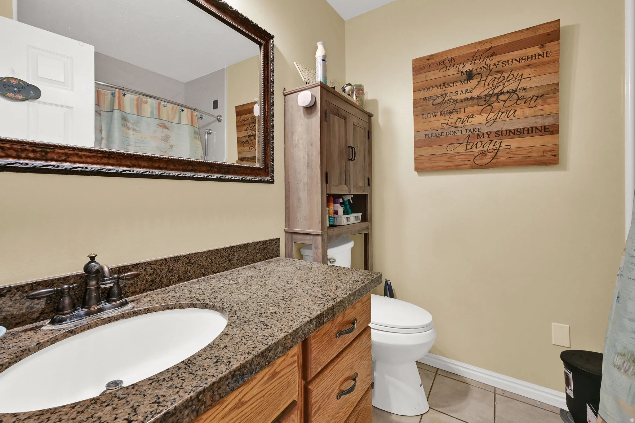 Bathroom with a shower, vanity, and light tile patterned floors