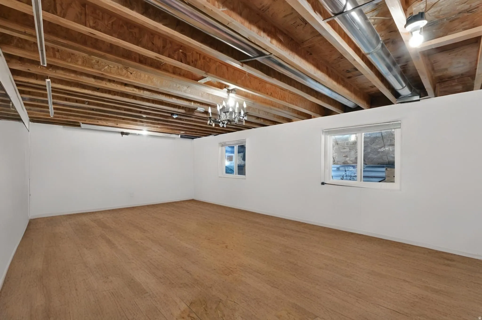 Dance room in basement with wood floors and mirrored wall could be used as additional bedroom, theatre room, rec room, gym, or man cave