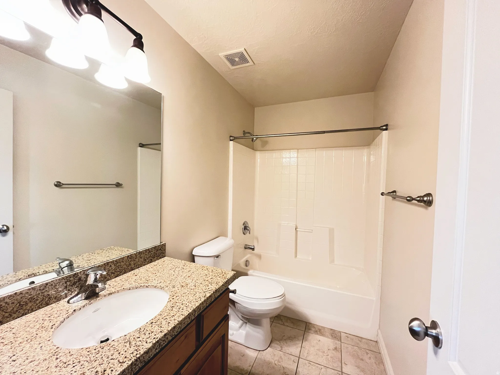 Full bathroom with vanity, shower / washtub combination, a textured ceiling, and light tile patterned floors