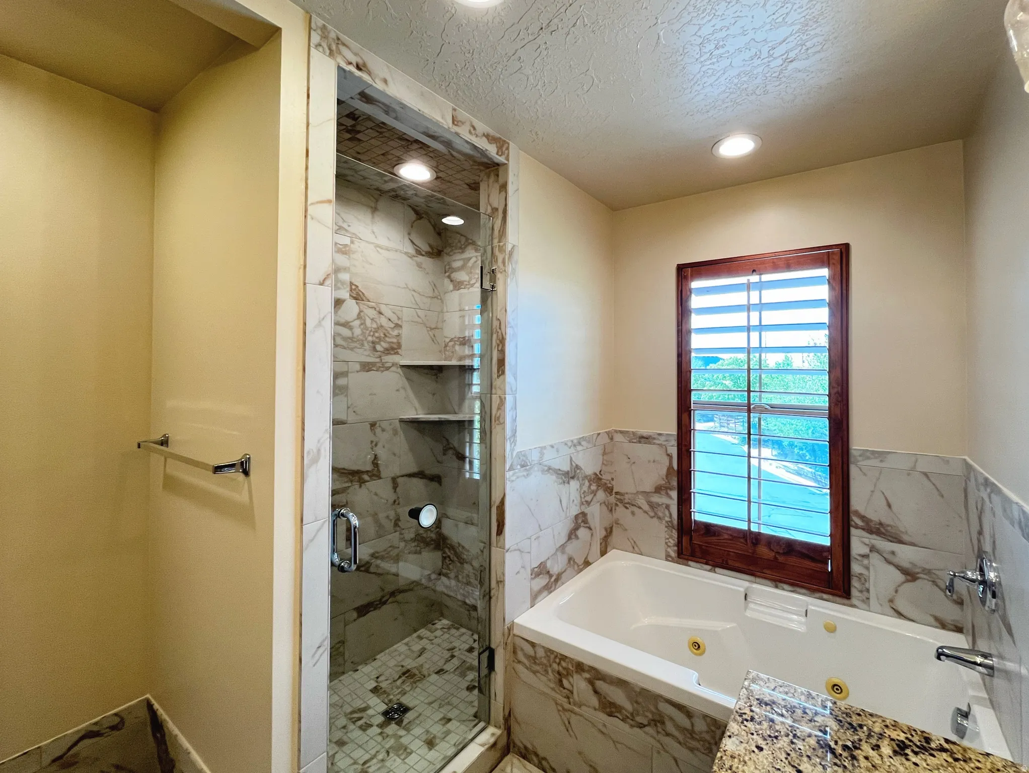 Full bathroom featuring a marble finish shower, recessed lighting, a tub with jets, and a textured ceiling