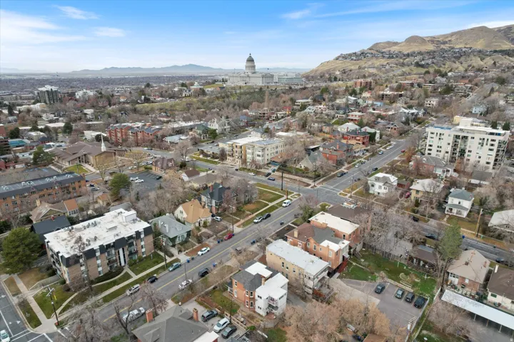 Aerial view of property and surrounding area with mountains and nearby urban area